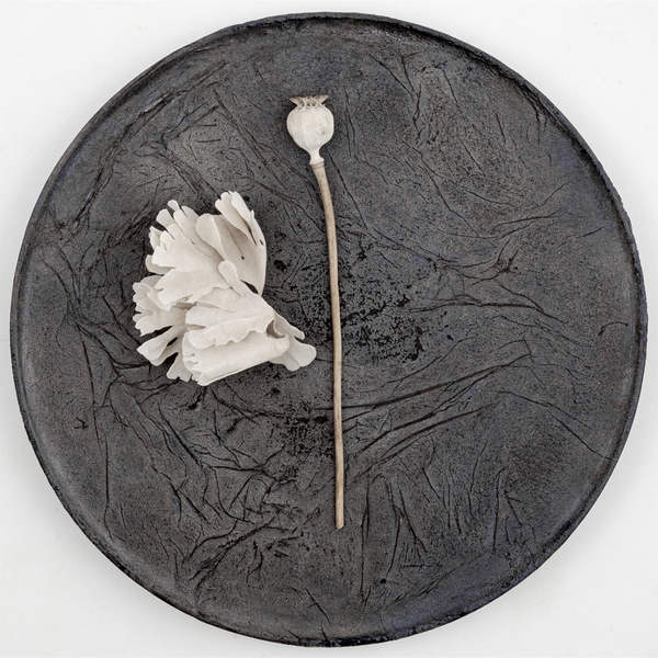 Top view of a large round wild cherry wood plate, textured with layers of washi paper and deep brown lacquer. Made in Japan from wood sourced from thinning projects in Yakushima and hand crafted by wood artisans Solmu Puut. On display with white dried flowers at NiMi Projects UK.