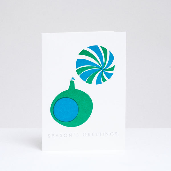 A Takako Copeland Christmas card, featuring two baubles hand-printed in green and blue.