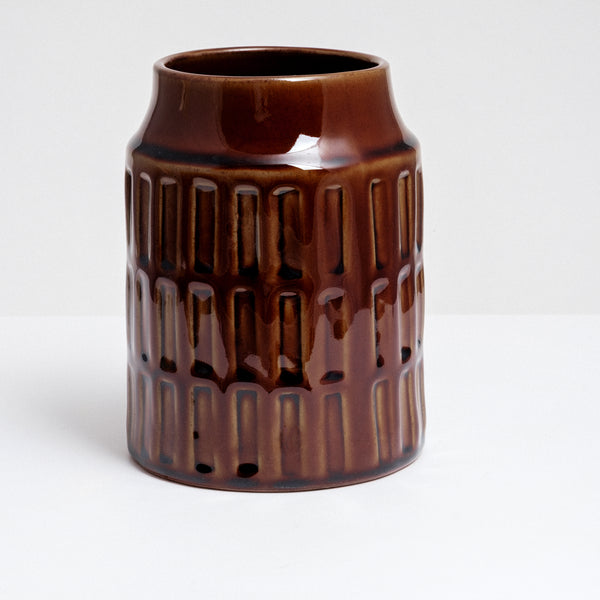 A cylindrical ceramic kitchen tool stand with a geometric pattern of three rows of rectangular indents and glazed in a rich, glossy brown. Made by Angle in Japan and available at NiMi Projects UK.
