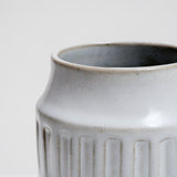 Close up of the top of a white glazed, cylindrical ceramic kitchen tool stand with a geometric pattern of three rows of rectangular indents. Available at NiMi Projects UK and made by Angle in Japan.