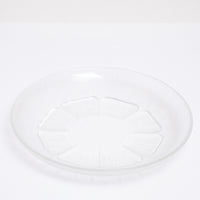 A small vintage Japanese glass plate, featuring a central flower motif with petals textured with lines that match the plates border. Available at NiMi Projects.