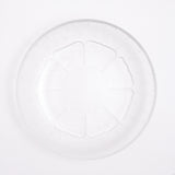 Top view of a small vintage Japanese glass plate, featuring a central flower motif with petals textured with lines that match the plates border. Available at NiMi Projects.