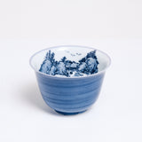 A vintage white porcelain Japanese teacup with a hand-painted blue exterior and a blue mountainscape inside. Available at NiMi Projects UK.