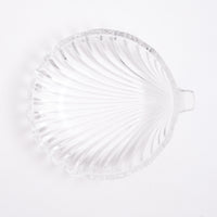 Top view of a heavy, vintage Japanese glass shell-shaped bowl, showing the arched lines of the shell shape from beneath and circular form. On show at NiMi Projects UK