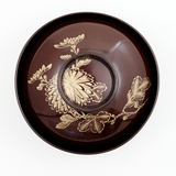 Ariel vew of a vintage Japanese lacuerware bowl, showing a gilt gold, hand-painted design of chrysanthemums across the lid. On show at NiMi Projects UK.