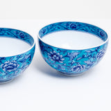 Two blue, vintage Japanese porcelain tea cups, featuring an outer glaze of turquoise blue decorated with an indigo blue pattern of flowering lotuses. Available at NiMi Projects UK.