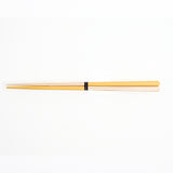 A yellow and wood pair of Style of Japan bi-colour Oedo hashi chopsticks, with a small black label wrapped around the centre with "Style of Japan" printed in white.