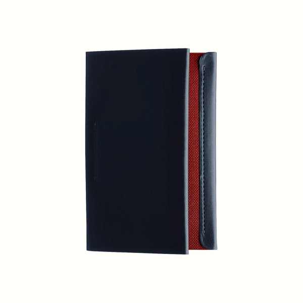A top view of a Postalco Card Holder with a navy blue soft cow-hide cover and red cotton textile inner.