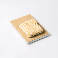 The Sankaku Vol. 02: Ramen book, featuring vacuum packed real instant ramen noodles as part of its cover. 