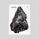 The white cover of the Sankaku Vol. 3: GODS book, featuring a large photographic image of a triangular, naturally formed dark grey rock. Published by sankaku and available at NiMi Projects UK. Photo by Sankaku.