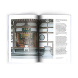 Inner pages of Sankaku Vol 3: GODS, a volume published by Sankaku and on show at NiMi Projects UK. On the left page, spreading halfway across onto the right page is a photograph of Horinji Temple main hall, showing its wooden beams and two monks sitting inside. On the right is text.