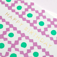A closeup of Takako Copeland’s Happy Birthday Card, showcasing the letterpress details of her pattern of purple diamonds and green circles, and gold foil-stamped lettering.