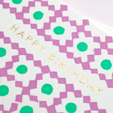 A closeup of Takako Copeland’s Happy Birthday Card, showcasing the letterpress details of her pattern of purple diamonds and green circles, and gold foil-stamped lettering.