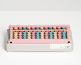 Japanese wooden abacus with pastel coloured beads, designed by Shinya Kobayashi and hand crafted in Japan by soroban artisans Daiichi. Available at NiMi Projects, UK.