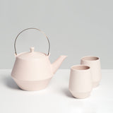 Off-white Japanese porcelain Frustum teapot, with brass handle and two matching tea cups, made in Japan and available at NiMi Projects.