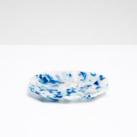 A side view of a recycled plastic polygon-shaped soap dish in mottled white and blue, made of ocean waste plastic by Buoy in Japan and on show at NiMi Projects UK.