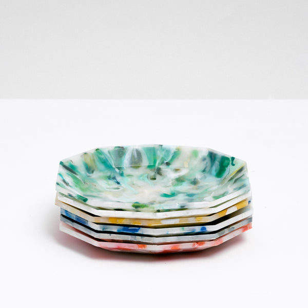 A stack of Buoy recycled plastic polygon soap dishes, each a different colour mottled with white — green, white, yellow, blue, grey and red — made in Japan and on display at NiMi Projects UK.