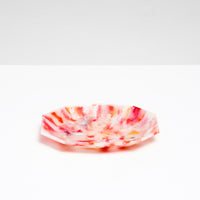 A side view of a NiMi Projects’ Buoy recycled plastic polygon-shaped soap dish in mottled white and red, made of marine waste plastic collected from the shores of Japan.Edit alt text