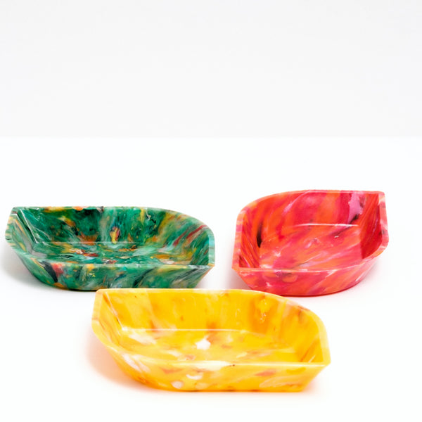 Three recycled marine plastic waste mini  leaf-shaped trays — one green, one red and one yellow — made by in Japan by Buoy, on display at NiMi Projects UK.