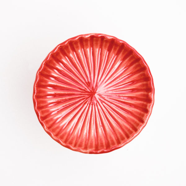 A red NiMi Projects' Hana Akari (flower light) radially fluted chrysanthemum dish.