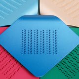 A detail of a square, royal blue, Japanese stainless steel Irogami kitchen grater available at NiMi Projects.