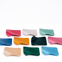 A group of different coloured Japanese Irogami kitchen graters lined up in three rows. Colours from top to bottom, left to right: red, silver, pale green, dark blue, yellow, black, pink, gold, deep green and pale blue.