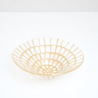 A large, handmade transparent conical Saburo Afumi fruit bowl, patterned with a grid of bright yellow, made in Japan and sold at NiMi Projects UK.