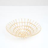 A large, handmade transparent conical Saburo Afumi fruit bowl, patterned with a grid of bright yellow, made in Japan and sold at NiMi Projects UK.