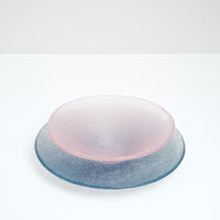 A round blue-purple Shari Shari glass platter paired with a pink Shari Shari conical fruit bowl, both featuring tiny bubbles trapped in the glass for a frosty effect, hand crafted by artisan Saburo in Japan and available at NiMi Projects UK.