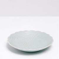 A side view of a vintage Japanese porcelain fluted edge side dish, featuring an indented pattern of a peony in full bloom, available at NiMi Projects UK.