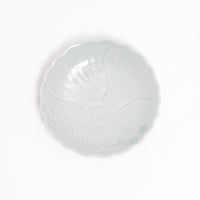 A small Arita ware Japanese porcelain fluted edge dish in celadon green, with an indented pattern of a peony in full bloom. A vintage piece on display at NiMi Projects UK.