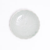 A small Arita ware Japanese porcelain fluted edge dish in celadon green, with an indented pattern of a peony in full bloom. A vintage piece on display at NiMi Projects UK.