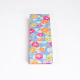A NiMi Projects UK Yuzen Washi Pen box, made with traditional chiyogami Japanese washi paper, featuring a pattern of neon pink, orange and yellow peonies on a blue background.