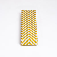 A Yuzen Washi Pen box, made in Japan from traditional chiyogami Japanese washi paper and featuring a herringbone patter in yellow, gray and white. Available at NiMi Projects UK.