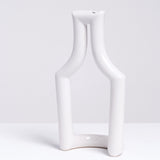 A white Still Green  porcelain tubular vase in the shape of a bottle, made by Ceramic Japan and sold at NiMi Projects UK.