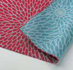 Detail of reversible cotton Japanese furoshiki wrapping cloth, featuring a bold traditional chrysanthemum print in red on one side and in sky blue on the other. Made in Japan and sold at NiMi Projects UK 