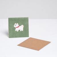 A green square Japanese Motif Mini Card, featuring an illustration of a white dog with a red collar, with a brown envelope. Printed in Japan and available at NiMi Projects UK.