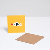 A square Japanese Motif Mini Card, featuring an illustration of fish-shaped bottle of soy sauce on a yellow backround, with a brown envelope. Printed in Japan and available at NiMi Projects UK.