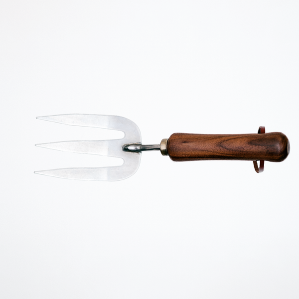 A stainless steel gardening fork with walnut wood handle and leather hanging strap, made by Asano Mokkousho in Japan's famous metalworking district Tsubame-Sanjo, and sold at NiMi Projects UK.