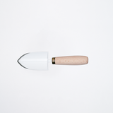 A mini trowel of white enameled stainless steel, made  in Tsubame-Sanjo, Japan's metalworking area, with a wood handle of snow beech sourced from forest thinning in Niigata. Sold as part of a gardening set by Asano Mokkousho at NiMi Projects UK.