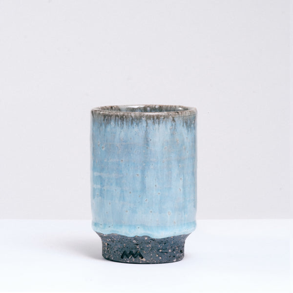 A large Asemi Iga-yaki Japanese tea cup, with a pale blue gradation drip glaze over a flecked dark grey clay, shot at NiMi Projects UK.