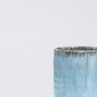 A closeup of an Asemi Iga-yaki Hydrangea Japanese tea cup, available at NiMi Projects,  showing details of the blue glaze on it's rim.