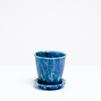 A blue Deco recycled marine plastic plant pot and saucer, made in Japan by the eco-friendly maker Buoy, which only uses plastic collected from beaches across Japan. Available at NiMi projects UK.