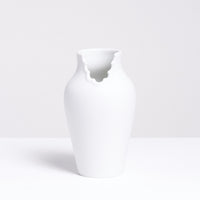 A Nendo x Ceramic Japan Dress Up vase in white porcelain, with a scalloped dress neckline to make it appear like a figure. Made in Japan by Ceramic Japan and available at NiMi Projects UK. 