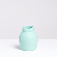 A small pale green porcelain Dress Up vase, designed by Nendo for Ceramic Japan, featuring a Peter Pan collar at its neck. Available at NiMi Projects UK.