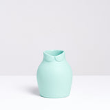 A small pale green porcelain Dress Up vase, designed by Nendo for Ceramic Japan, featuring a Peter Pan collar at its neck. Available at NiMi Projects UK.