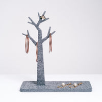 A grey tree-shaped trinket stand, displaying NiMi Projects jewelry, designed by Feelt and made in Japan from a recycled polyester textile.