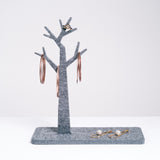 A grey tree-shaped trinket stand, displaying NiMi Projects jewelry, designed by Feelt and made in Japan from a recycled polyester textile.