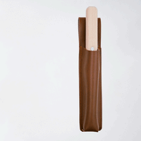 A gif animation of a NiMi Projects' Japanese Asano Mokkousho Hori Hori gardening tool, a mini trowel with a serrated edge and snow beech handle, shown going in an out of a faux leather holder.