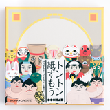 The box of Kokuyo's Tonton paper sumo wrestling game, featuring a sumo ring on which to play the game and an illustration of the sumo characters of the game, including sumo wrestlers, a wild boar, a cat, sheep and more. Available at NiMi Projects